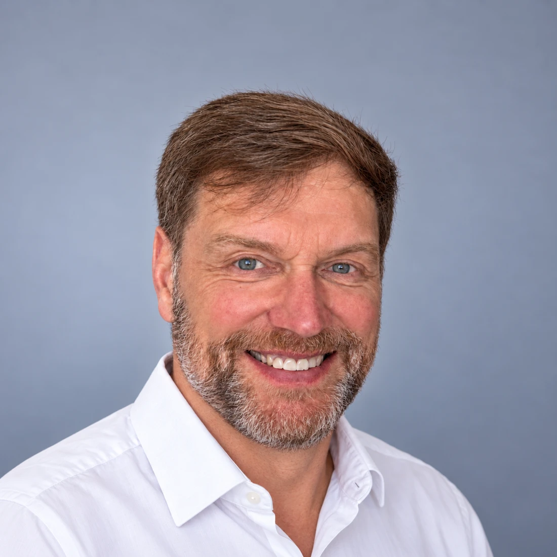 Peter Bösing im weißen Hemd, freundlich in die Kamera blickend